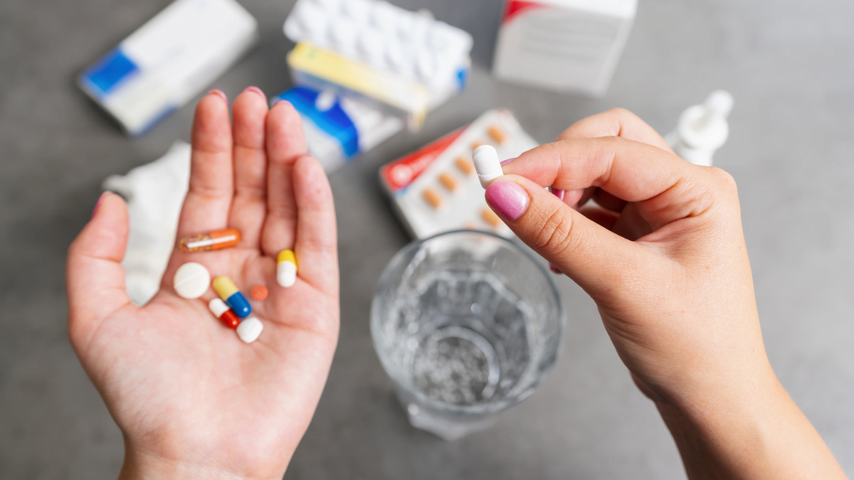 can you take adderall and wellbutrin - a hand holding a pill and a glass of water